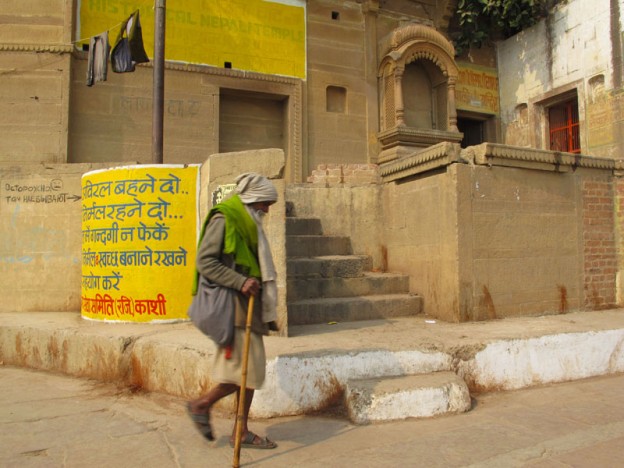 Man Walking Along the Ganges Ghats in Varanasi, India